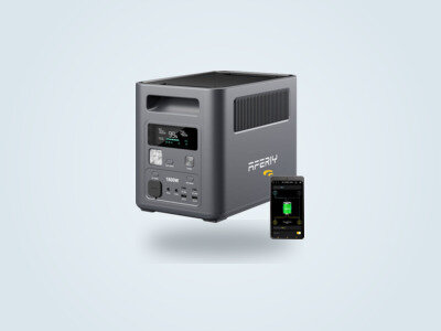 Estación de energía portátil Aferiy P180 vista de tres cuartos, pantalla LCD encendida mostrando el 99 por ciento de carga, app de control visible en una ventana superpuesta