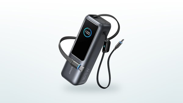 Anker A1695 power bank seen at a three-quarter angle, display lit at 100 %, retractable USB-C cable and built-in cable extended on either side of the case