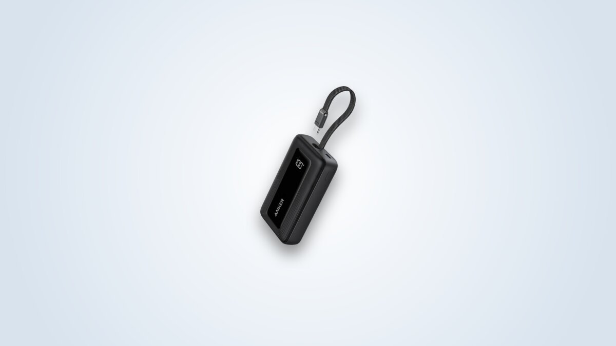 Black Anker Zolo 20000 power bank with its built-in USB-C cable unfolded and its screen showing the battery percentage