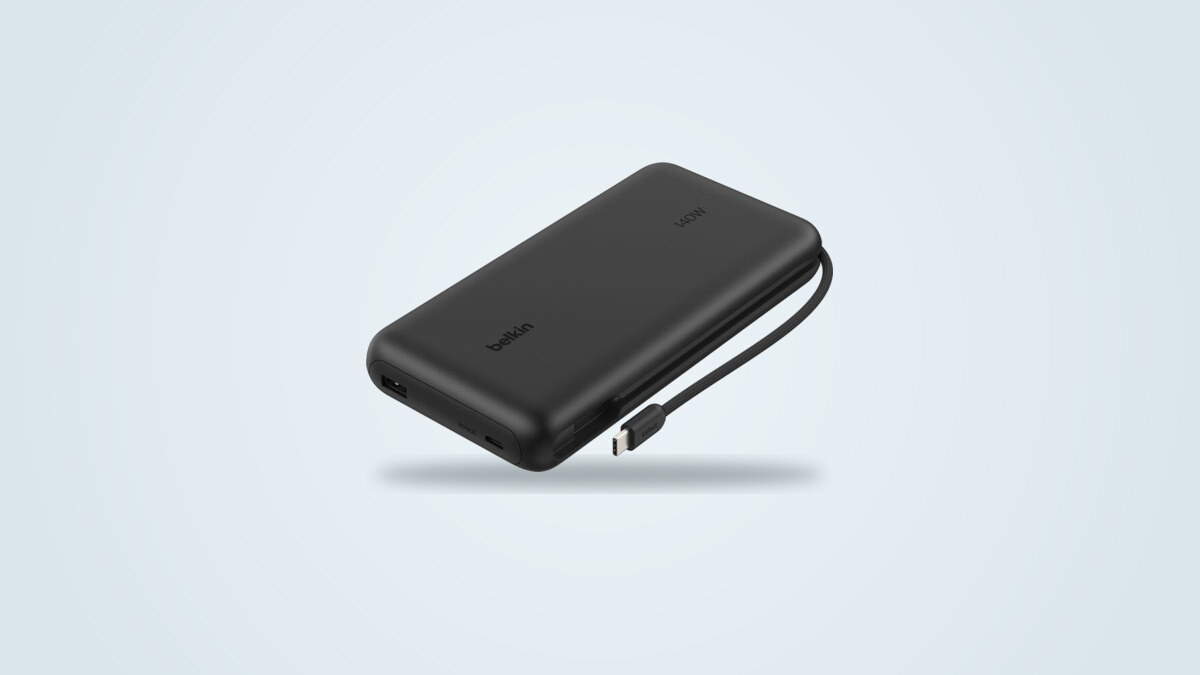 Belkin UltraCharge Pro 25K power bank shown at a three-quarter angle with its built-in USB-C cable unrolled and its digital display showing the charge percentage