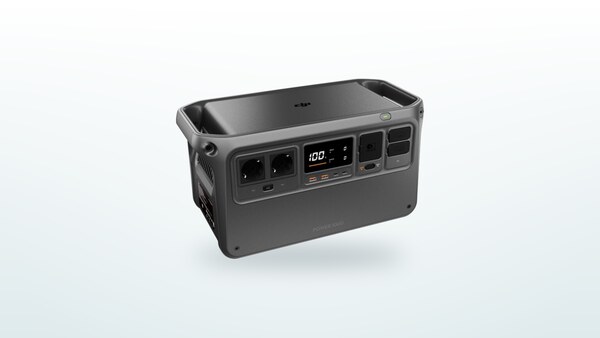 DJI Power 1000 portable power station at three-quarter angle, screen lit showing charge percentage, SDC ports visible