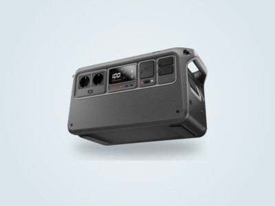 DJI Power 1000 V2 portable power station at a three-quarter angle, screen lit showing 100%, SDC ports and folding handle visible