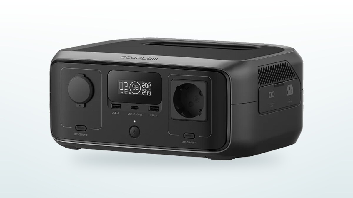 EcoFlow River 3 portable power station seen three-quarters on, display lit, Schuko mains socket and 100 W USB-C port visible on the front panel