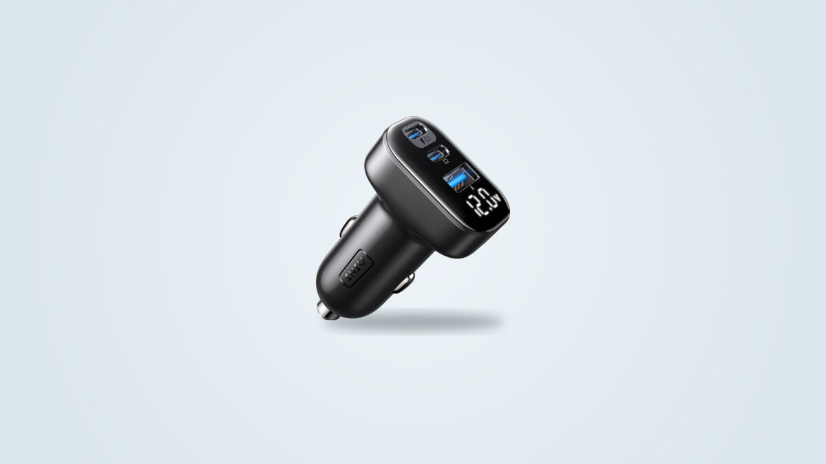 INIU 90W car charger seen at an angle, USB-C and USB-A ports and lit voltage display visible