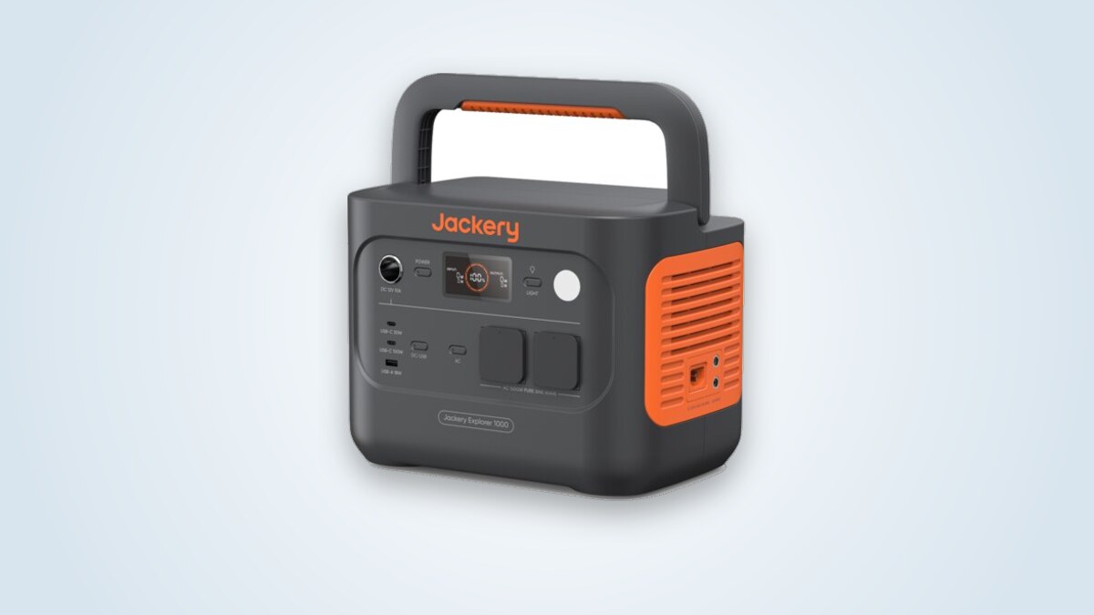 Jackery Explorer 1000 v2 portable power station at three-quarter angle, handle raised, screen lit and 230 V sockets visible