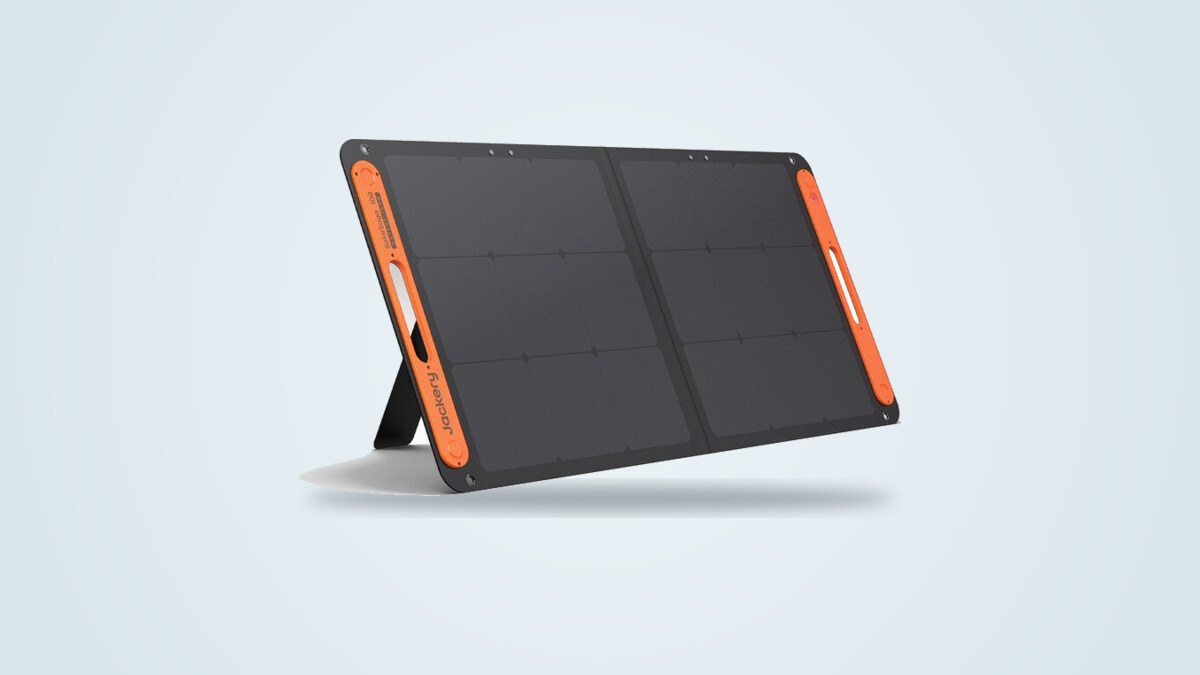 Panneau solaire pliable Jackery SolarSaga 100W déployé sur ses béquilles, cellules monocristallines et poignées orange visibles
