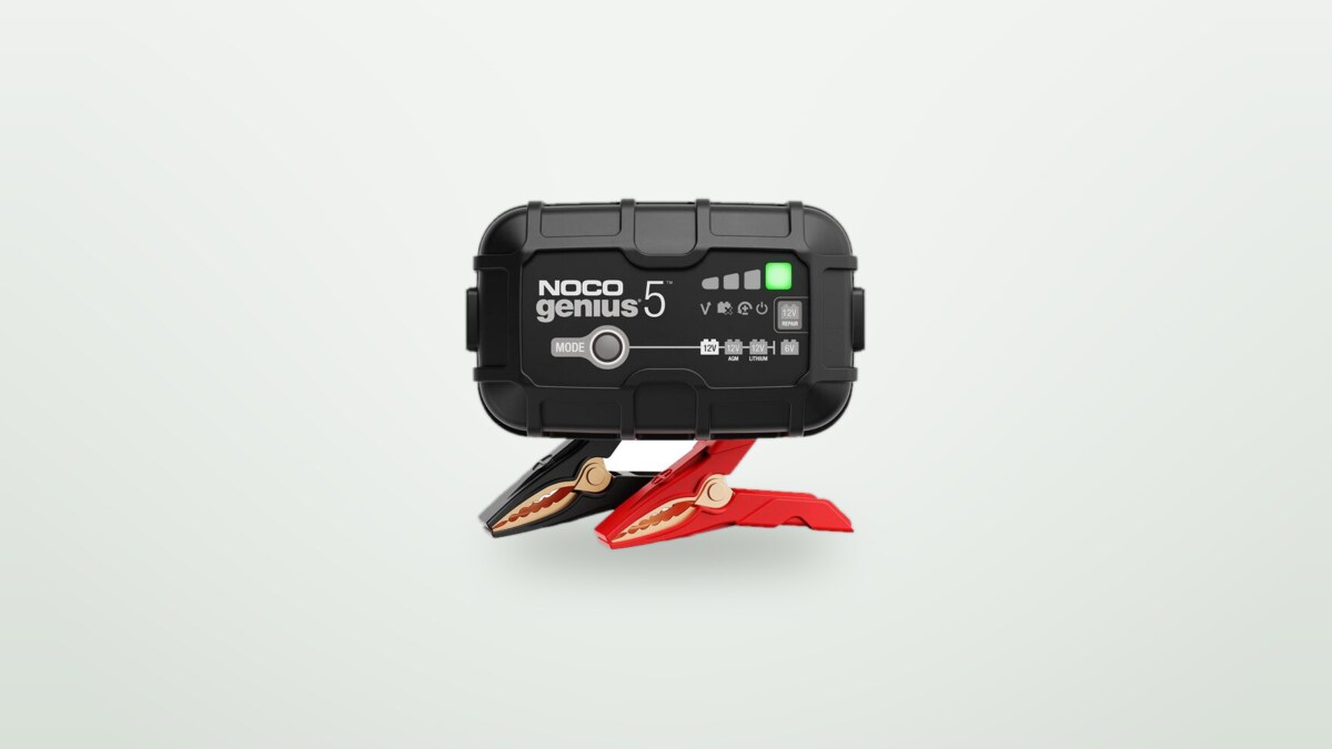 Batterieladegerät Noco Genius5 mit seinen Ladeklemmen vor hellem Hintergrund