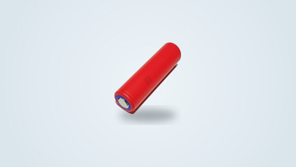 Celda de iones de litio Panasonic NCR18650GA en formato 18650, funda roja, polo positivo plano (Flat Top), sobre fondo claro