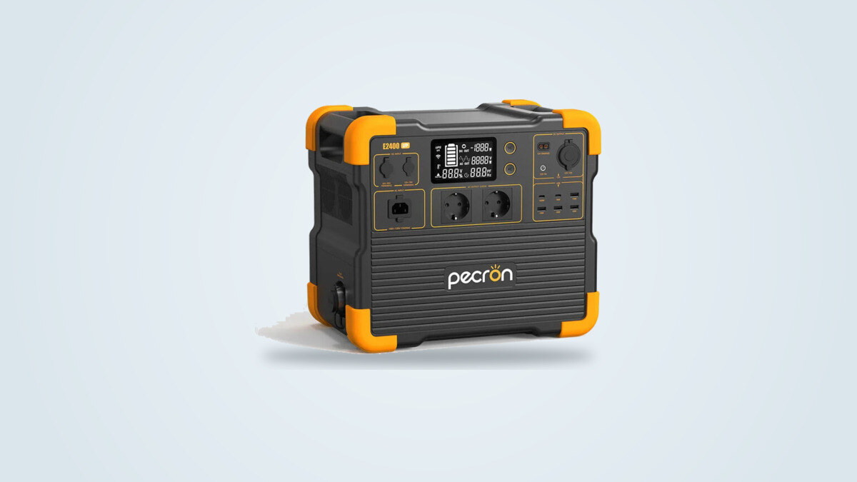 Pecron E2400LFP portable power station at a three-quarter angle, screen lit showing charge and power flows, two European mains sockets visible