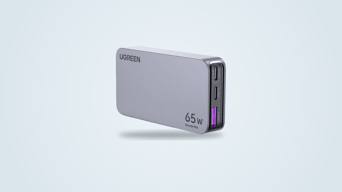 Ugreen Nexode Pro 65W Slim wall charger seen from a three-quarter angle, flat light grey case with two USB-C ports and one USB-A port visible on the edge