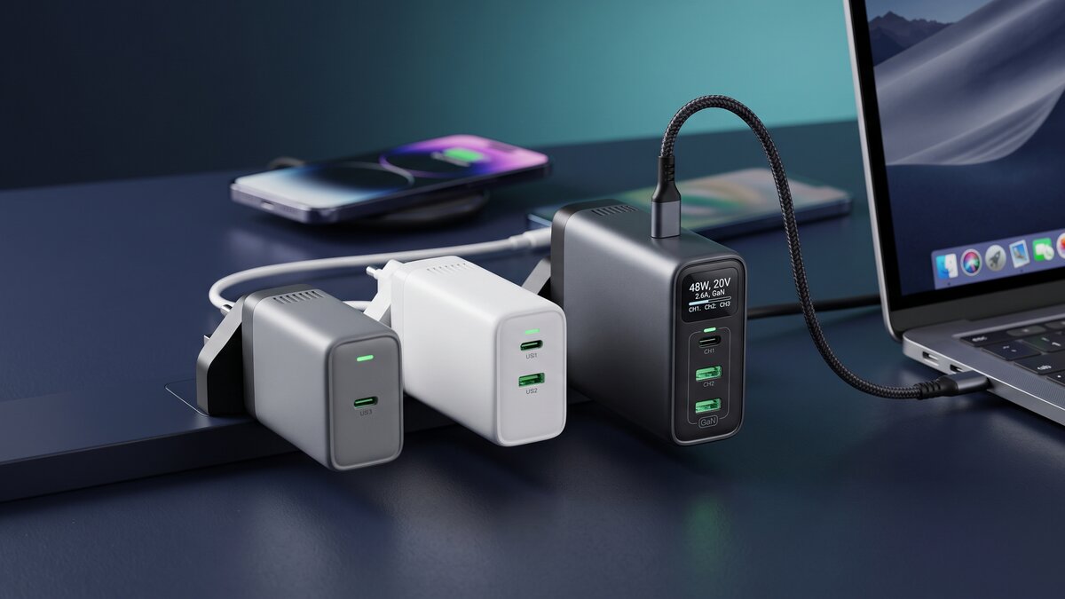 Mehrere GaN-Ladegeräte mit mehreren USB-C-Anschlüssen auf einem Schreibtisch, daneben ein ladendes Notebook und Smartphone