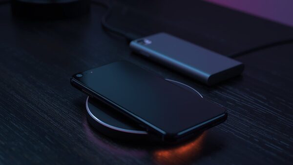 Smartphone cargando en un cargador inalámbrico magnético Qi2 MagSafe, junto a una batería externa magnética